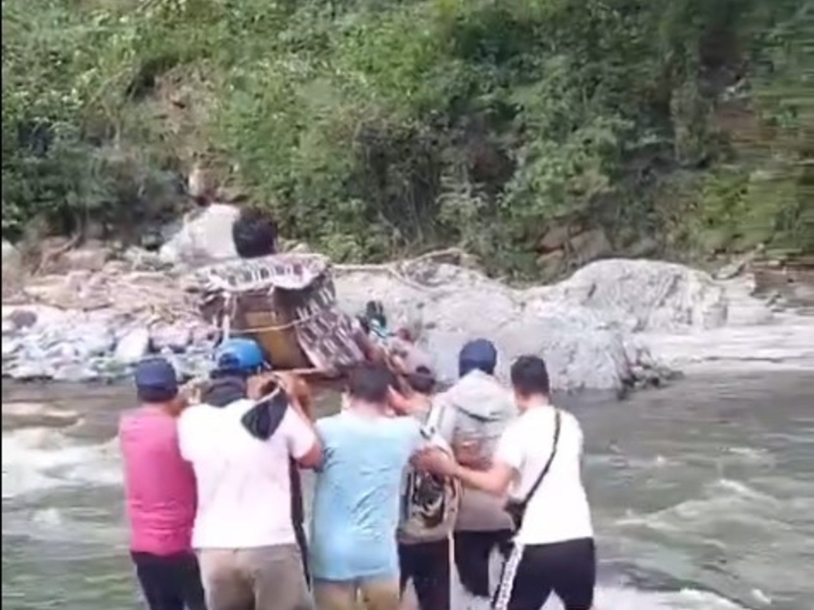 aislados por las lluvias, tuvieron que armar una camilla para cruzar a un enfermo por un río