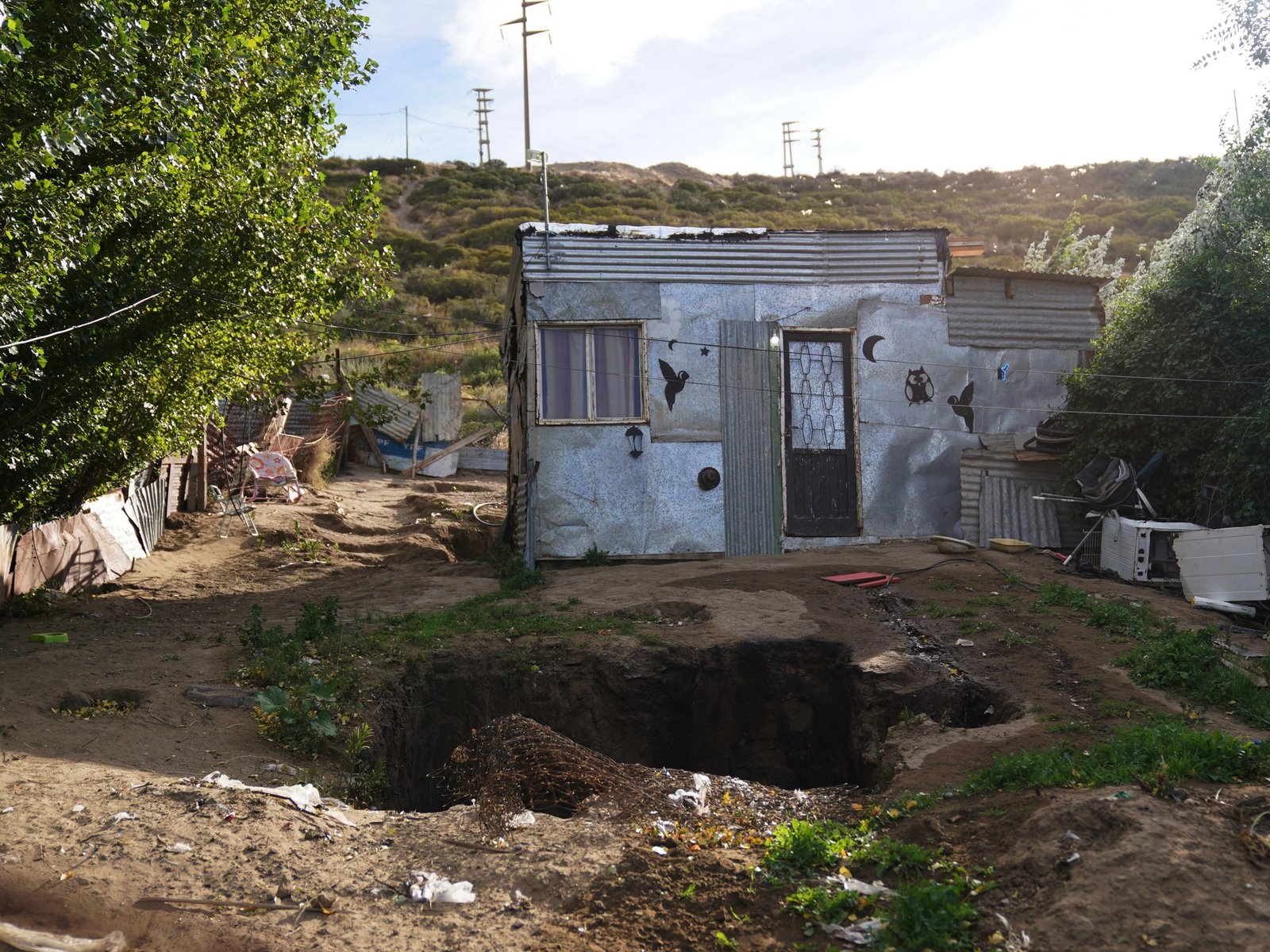 un techo de chapa con goteras y la cama en un rincón