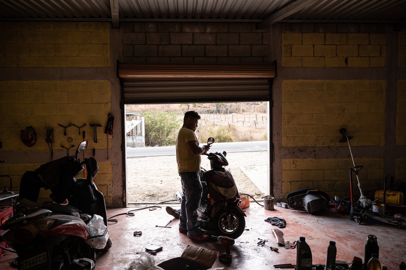 Andrés repairs the side mirror of a scooter in his auto repair shop in El Estoraque, in the village of Amatón, Quezada, Jutiapa, on March 13, 2026.