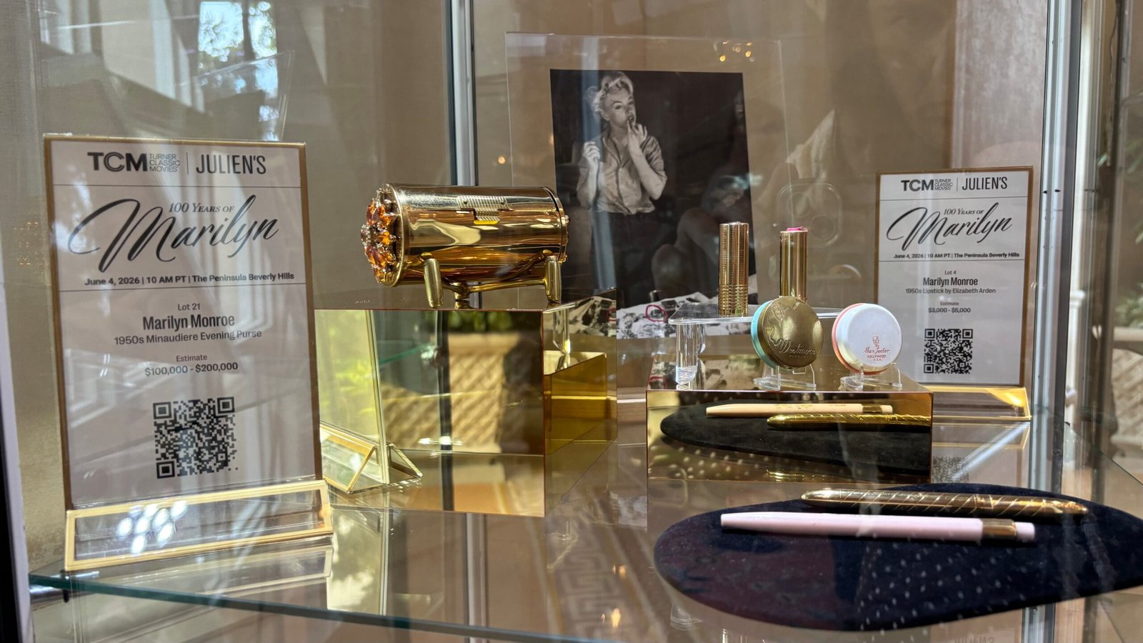 Varios objetos de Marilyn Monroe expuestos en la subasta de Julien's Auctions celebrada en el hotel Peninsula de Beverly Hills el 4 de junio de 2026. A la izquierda, un bolso dorado; a la derecha, de arriba abajo, barras de labios, pintalabios redondos, una máscara de pestañas y un lápiz de ojos.