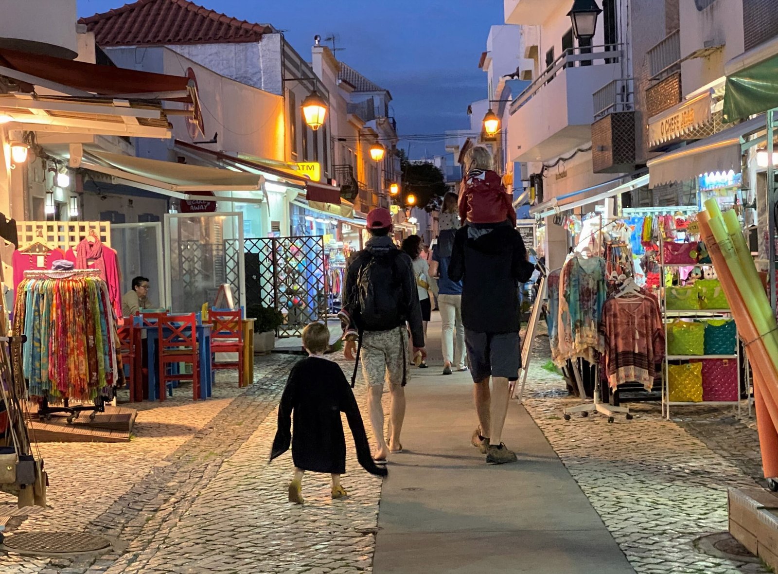 Una familia pasea al anochecer por las calles de Alvor (Portugal), una de las escenas habituales del verano, cuando los horarios suelen relajarse.