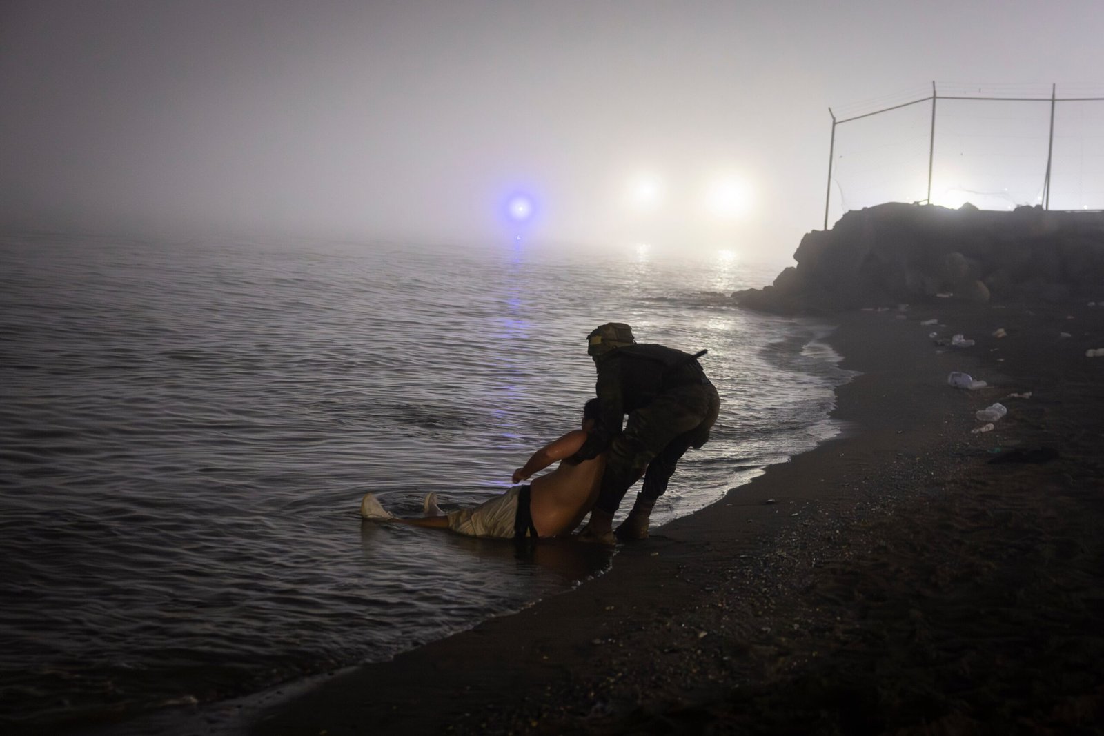 Un soldado español salva a un hombre llegado a nado en la playa de El Tarajal en la madrugada de este sábado.