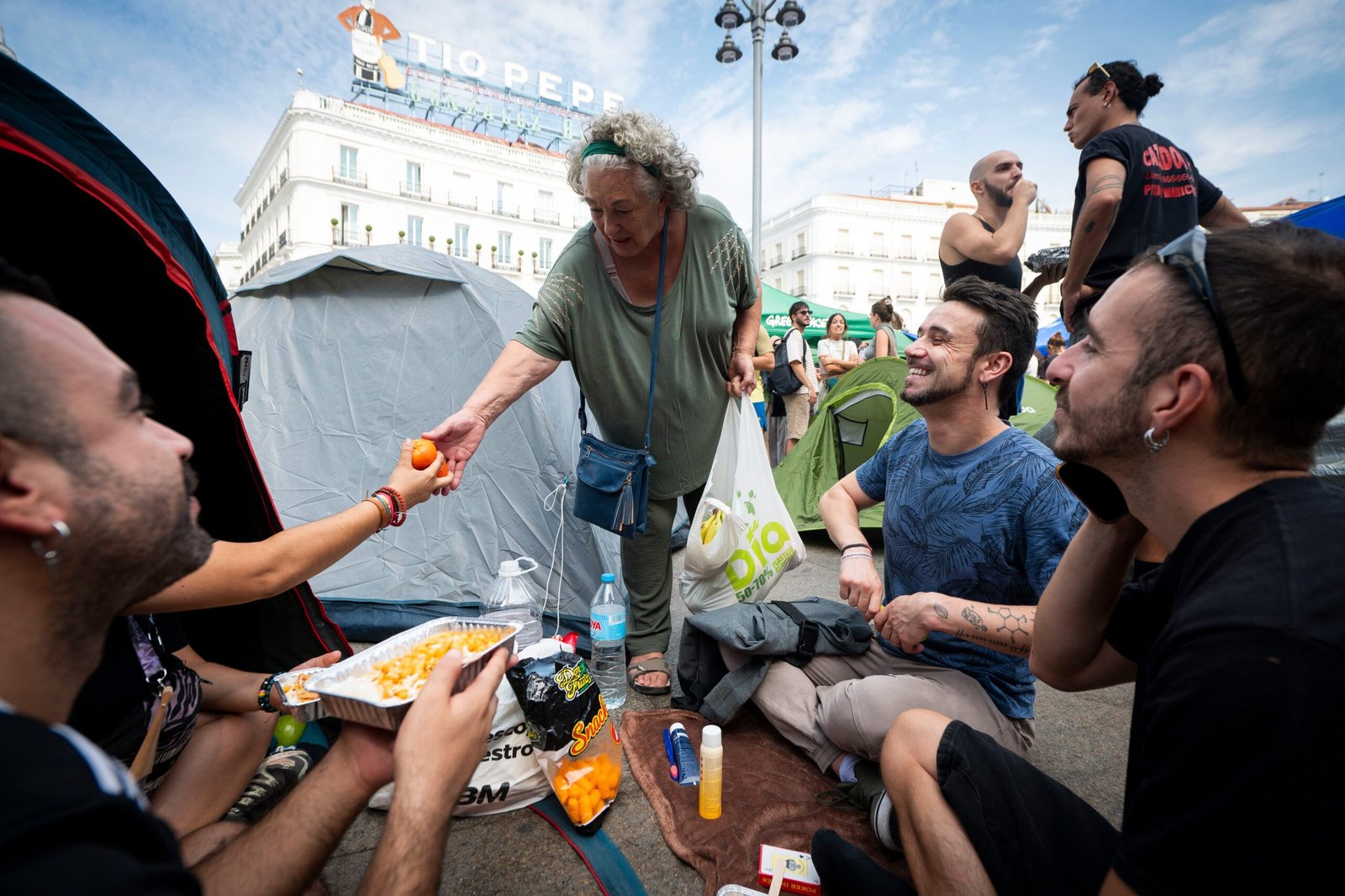 Amalia Sánchez, repartiendo mandarinas a los acampados en la Puerta del Sol el domingo por la mañana, 27 de septiembre, en Madrid.