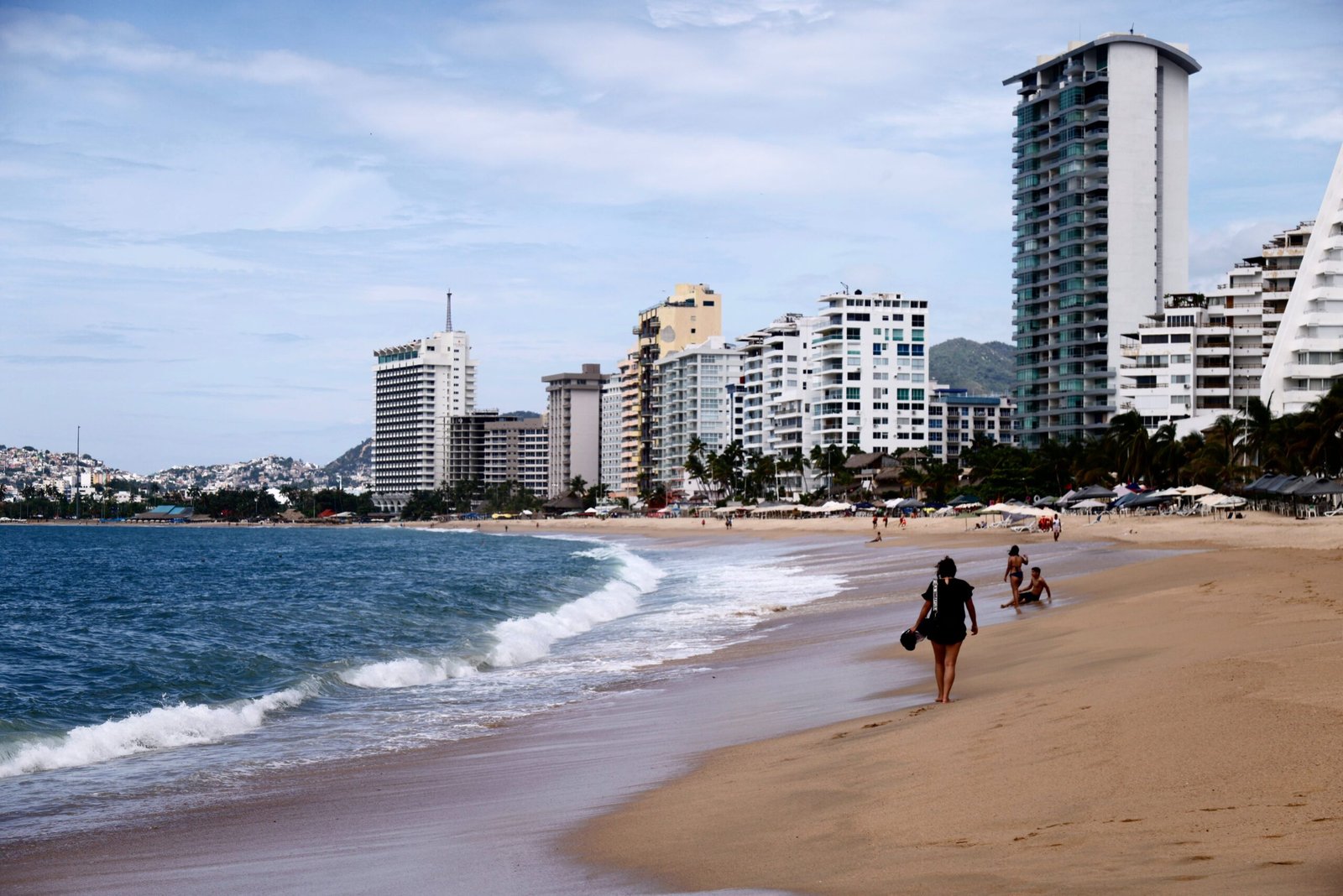 Turistas caminan en la costa de Acapulco, Guerrero, este jueves.