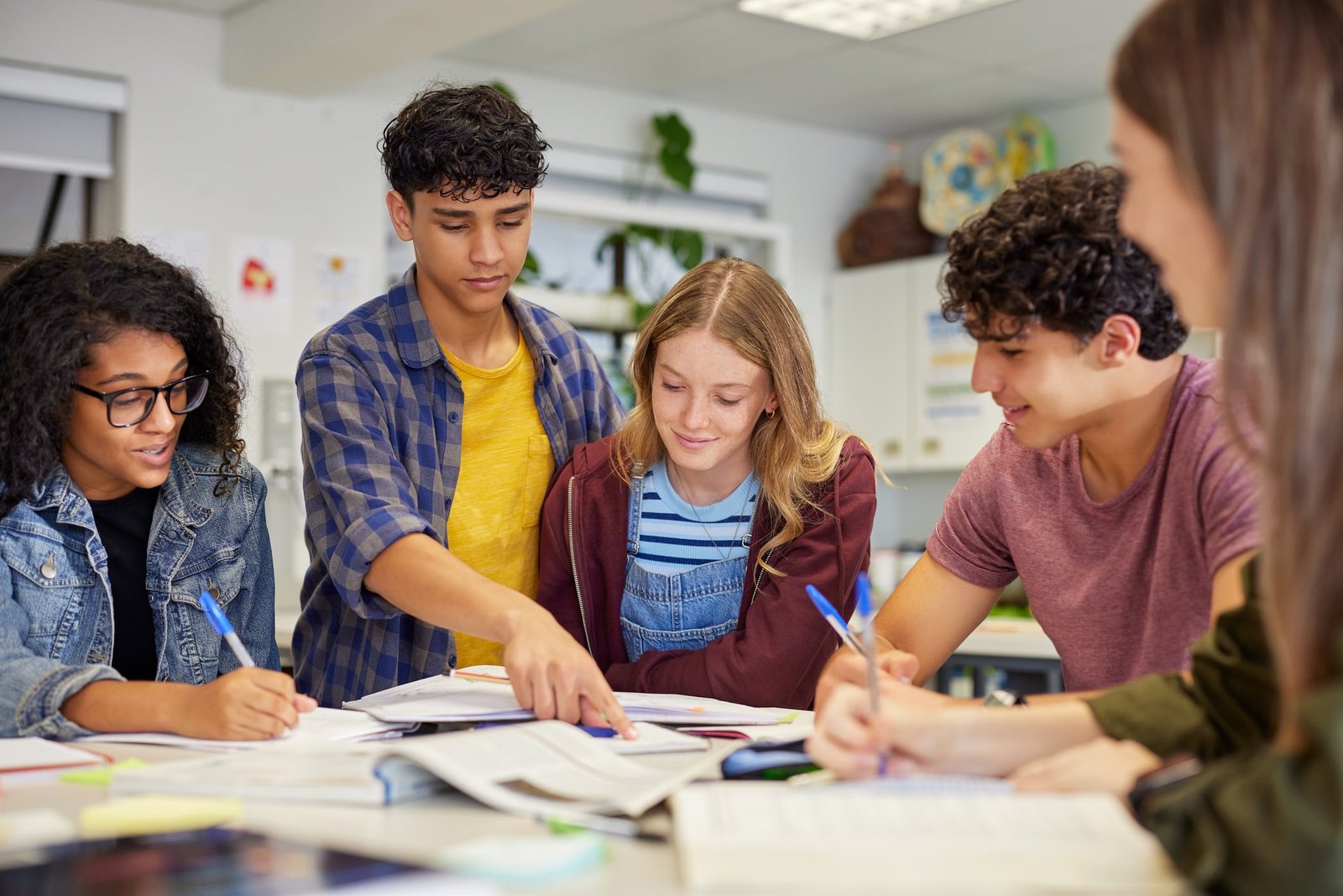Alumnos de secundaria trabajan juntos en un proyecto de clase.